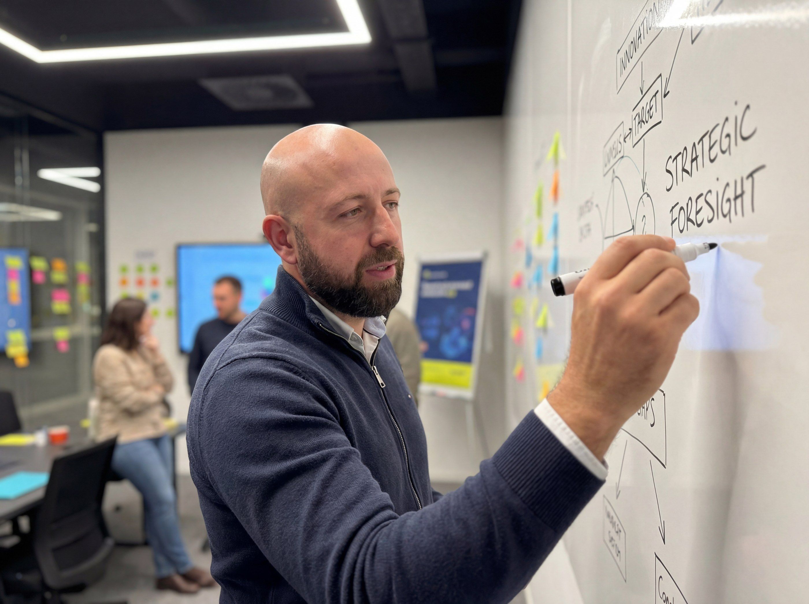 Alexander Balabanov drawing a strategy diagram on a whiteboard during a workshop